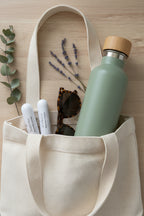 Two nasal inhalation sticks sticking out from a tote with sunglasses and a water bottle showing the portability of the nasal inhalation sticks.