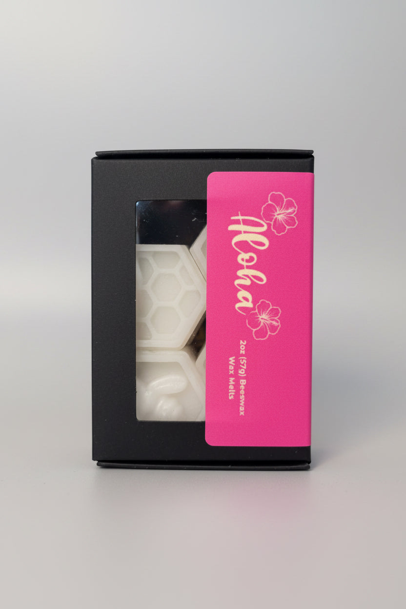 Box of Aloha beeswax melt candles with a pink label on a white surface.