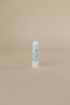 White bottle with blue label on a beige background