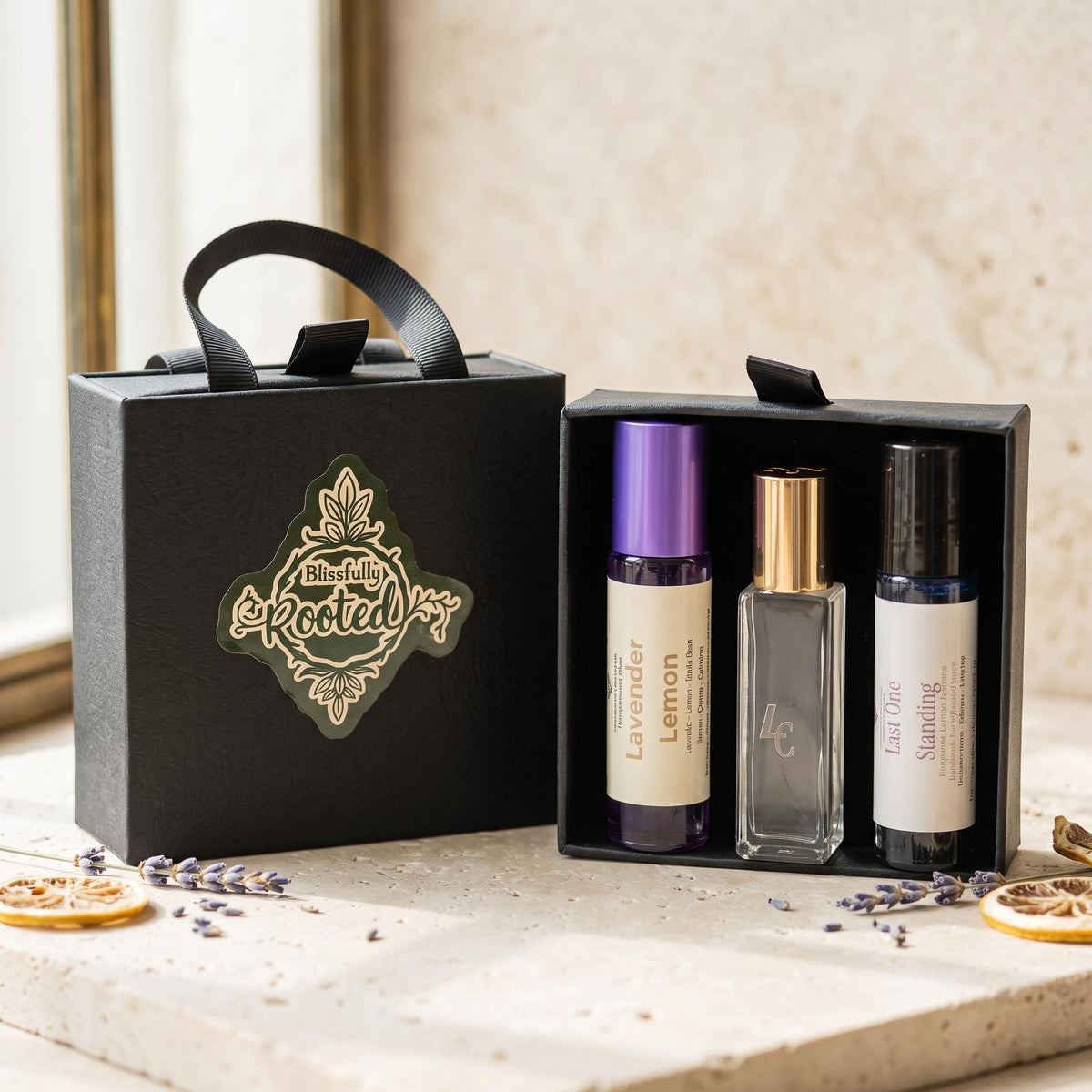 Trio of rollers in a black gift box with black box next to it with the Blissfully Rooted logo on the front.  