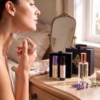 Woman facing a window applying Luxe Cashmere roller to her neck with Luxe Cashmere perfume and two more rollers on a vanity.