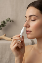 Breathe Easy aromatic inhaler held close to the nose of a woman with her eyes closed. 