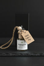 Small bottle with a wooden cap labeled Distinguished Gentleman with a gift tag showing the gift giving possibility of the Distinguished Gentleman Car Diffuser.  