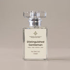 A 30ml clear glass bottle of cologne with a silver cap and a cream-colored label reading 'Distinguished Gentleman'. The bottle is centered against a solid, warm beige background.