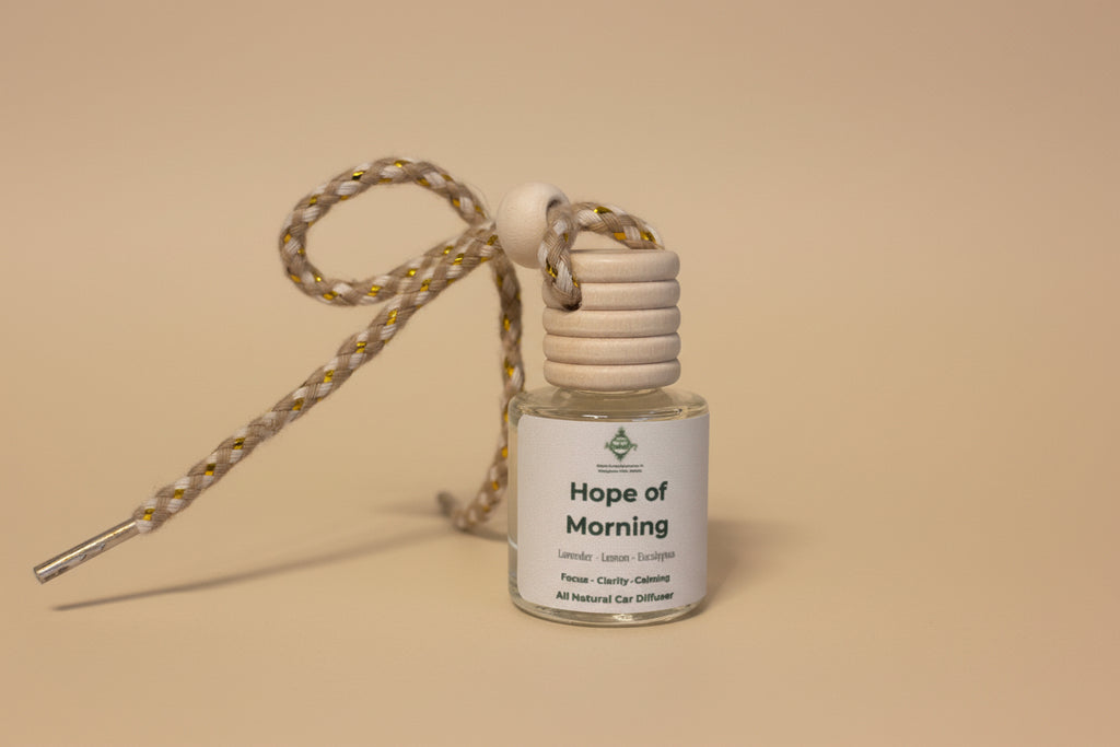 Small bottle labeled 'Hope of Morning' with a strap on a neutral background
