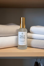 Frosted Bottle with Hope of Morning on the label in a closet next to clean linens for a whole home freshness.  