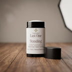Deodorant container labeled 'Last One Standing' on a wooden surface with a blurred background