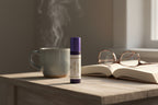 Lavender Lemon Roller on a nightstand with a book and mug for winding down.  