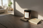 Jar of lavender lemon candle on wooden table with living room in the background. 