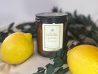 Candle labeled 'Lavender Lemon' with two lemons and green leaves on a white surface.
