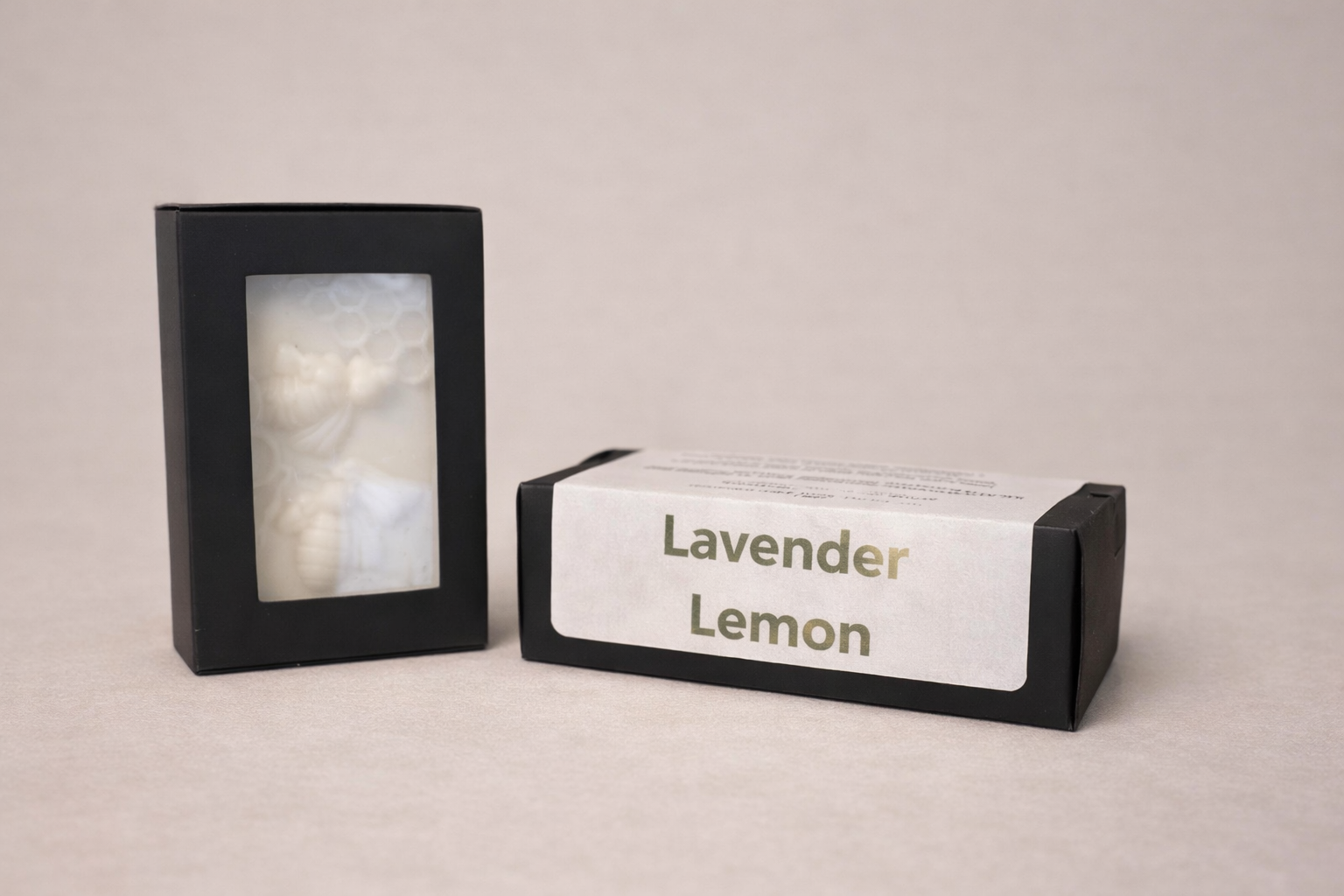 Black rectangular container with a photo on a beige background, next to a box labeled 'Lavender Lemon'.