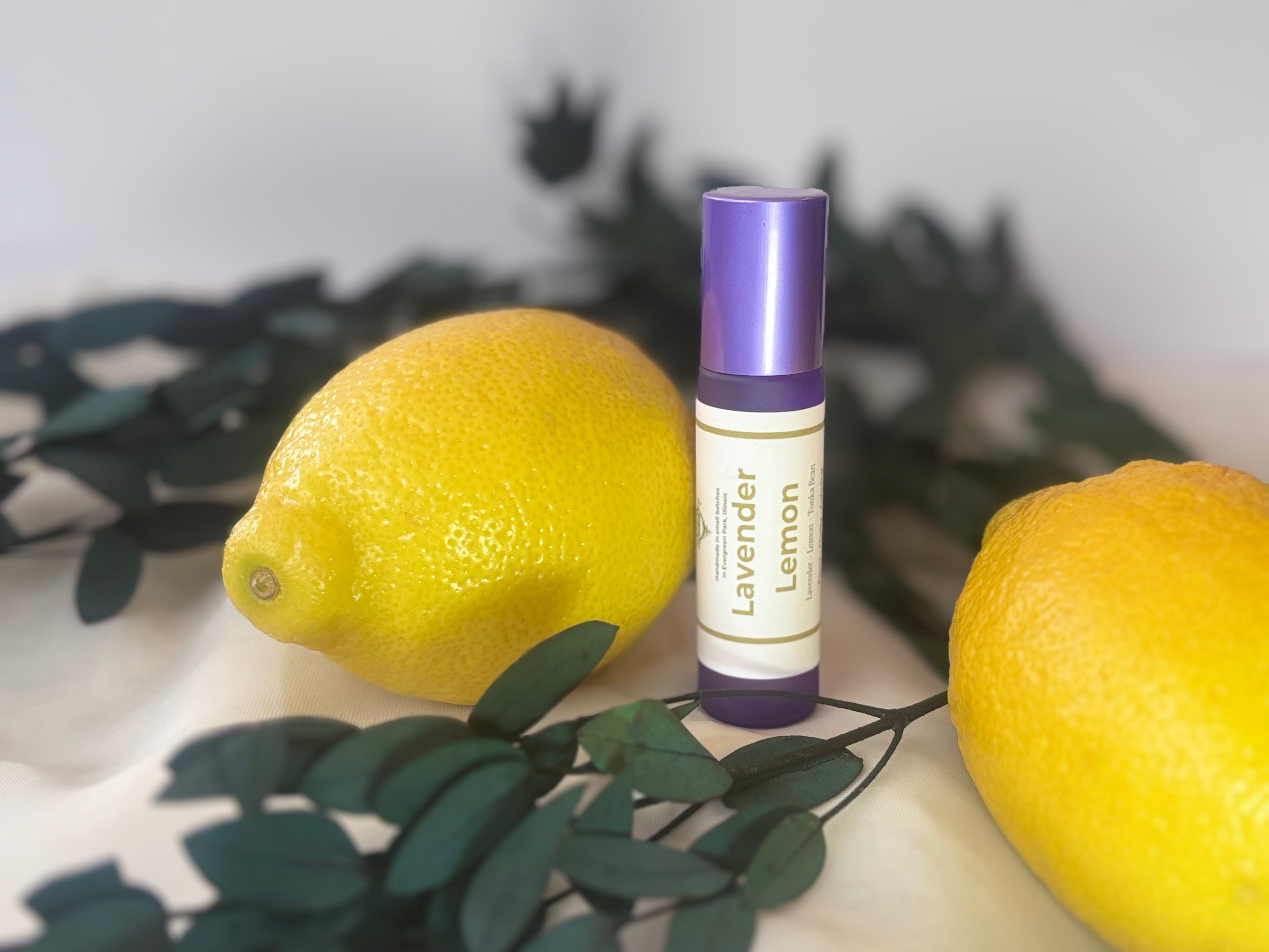 Roll-on bottle labeled 'Lavender Lemon' with two lemons and green leaves on a white background