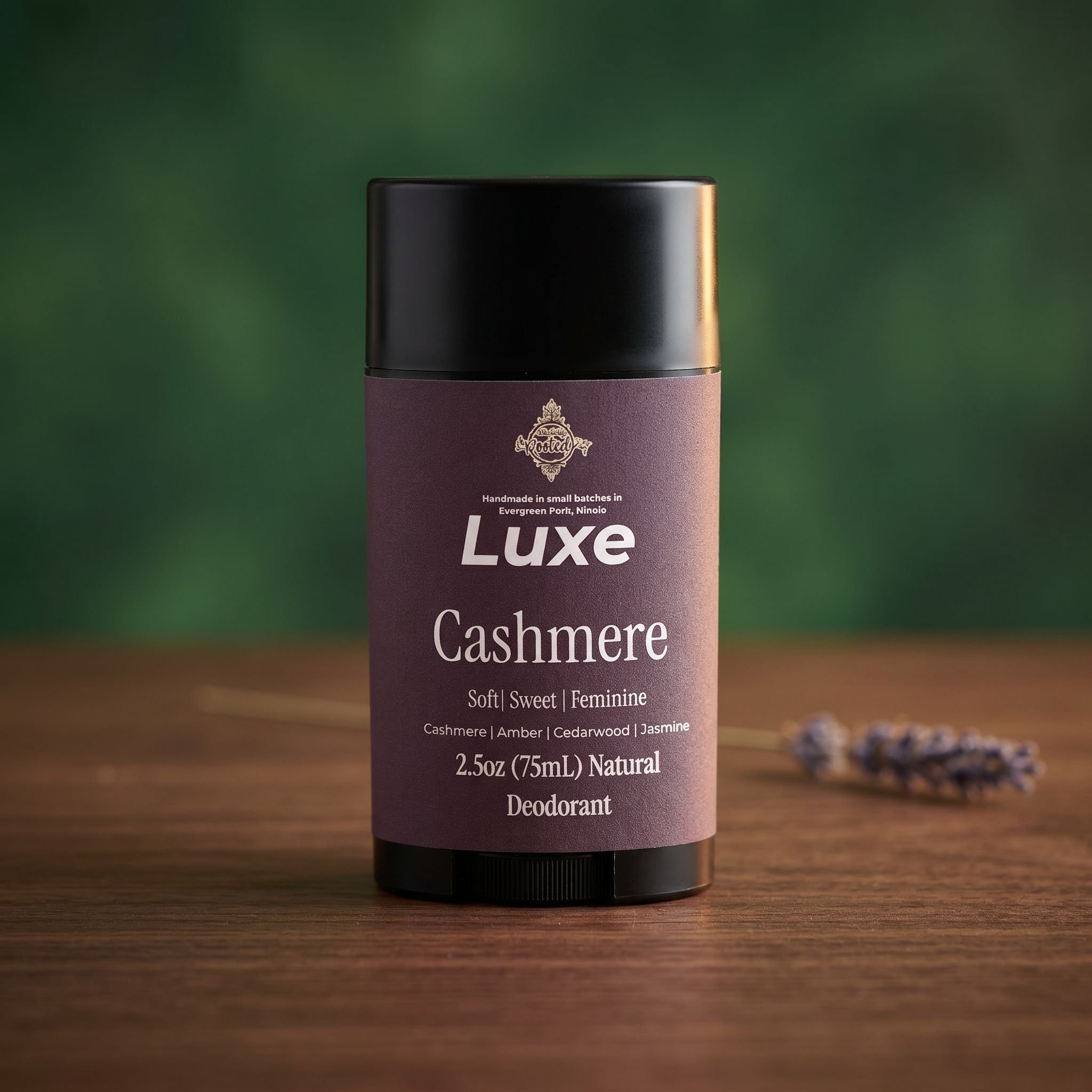 Luxe Cashmere deodorant container on a wooden surface with a blurred green background
