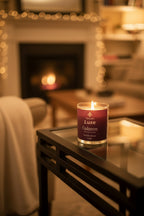 Candle with brown label on table in cozy living room with soft throw blanket over sitting chair