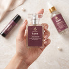 Hand holding a Luxe Cashmere perfume bottle with other perfume bottles in the background.