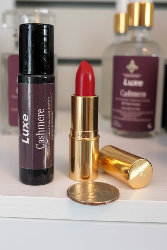 Luxe Cashmere perfume roller with gold casing and red lipstick on a white surface with 'Luxe' branding.