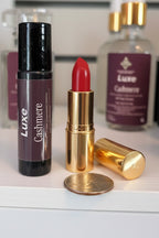Luxe Cashmere perfume roller with gold casing and red lipstick on a white surface with 'Luxe' branding.