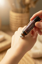 Black Luxe Cashmere perfume roller being rolled onto a wrist in soft lighting to show softness of the scent. 