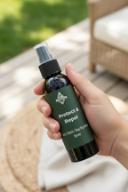 Black spray bottle with protect and repel label in a hand to show travel size