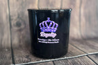 Black candle vessel with title Royalty on wooden surface.