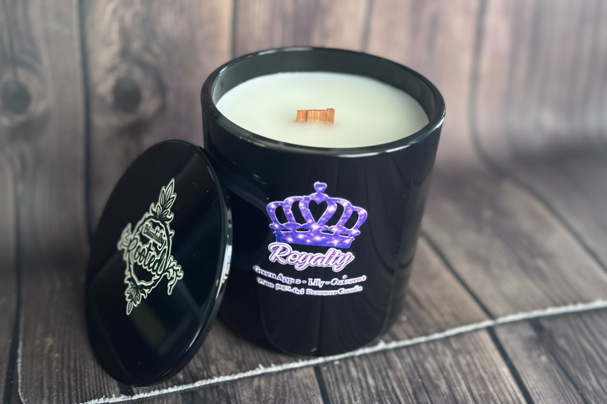 Black candle with 'Royalty' branding on a wooden surface