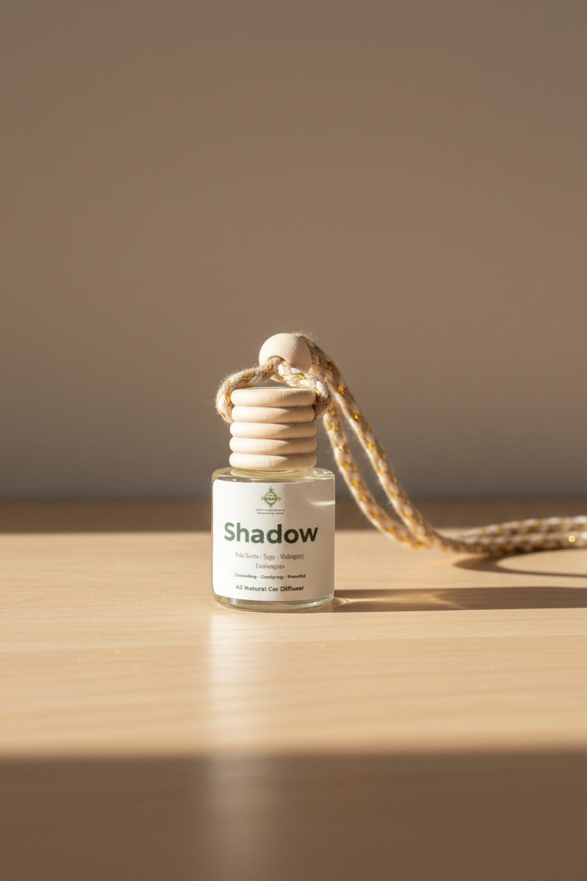 Small bottle labeled 'shadow' with a wooden neck and natural fiber chain on a neutral background