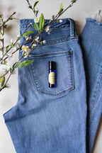 Sunkissed Jeans Roller laying on a pair of jeans with flowers.
