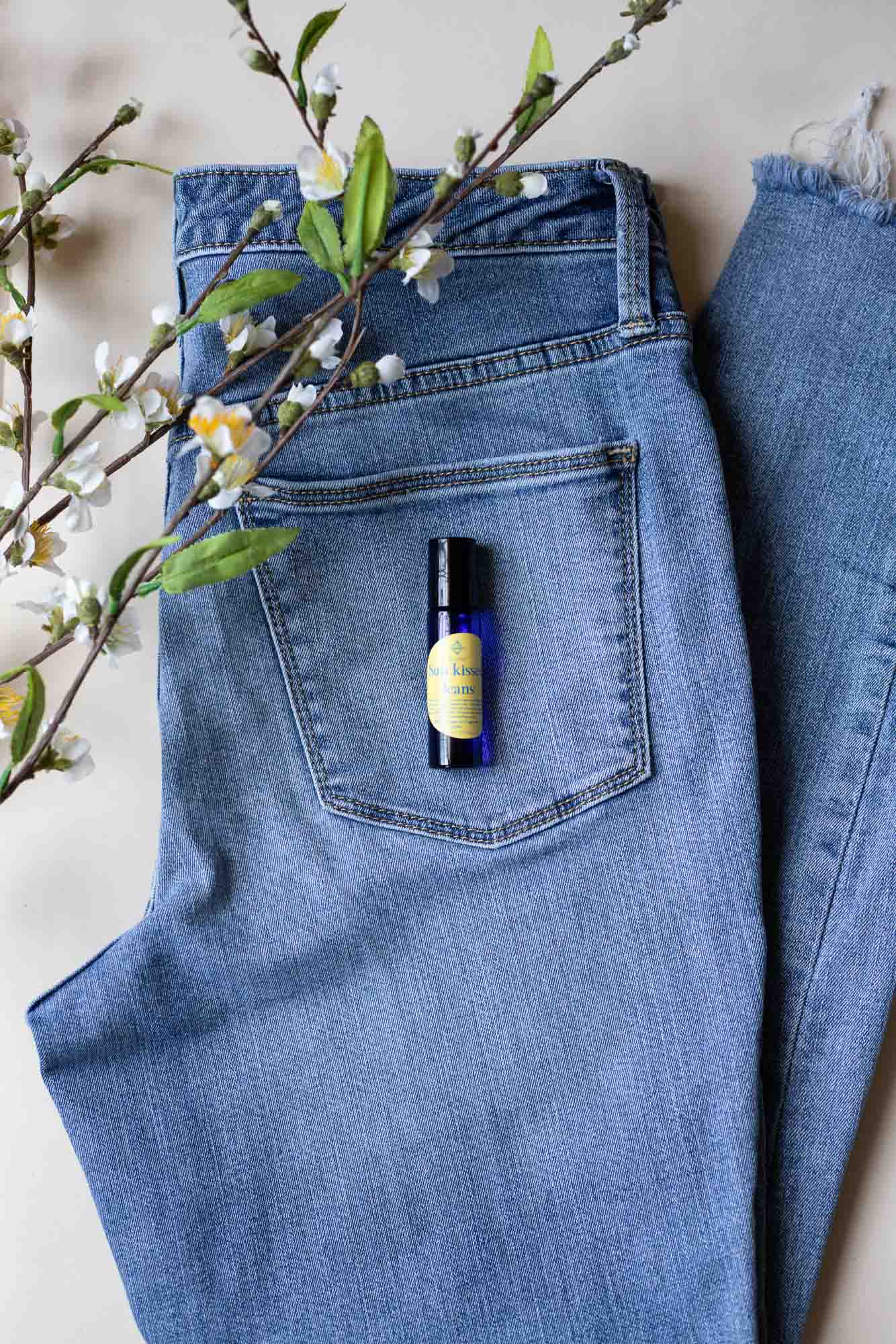 Sunkissed Jeans Roller laying on a pair of jeans with flowers.