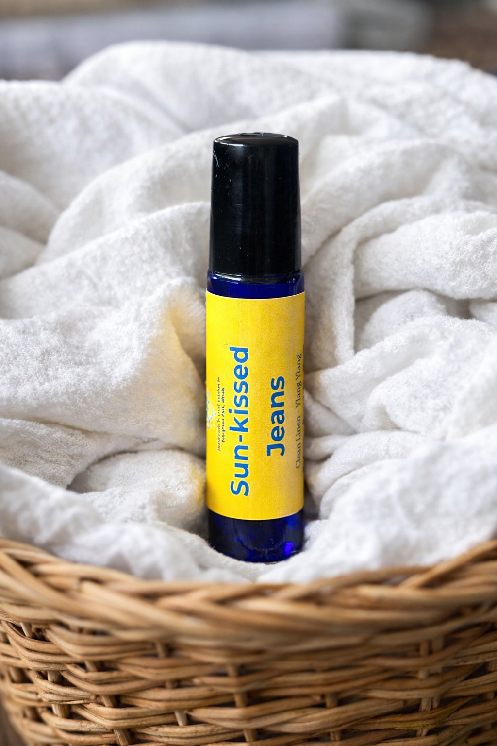 Sunkissed Jeans Roller in basket of clean white sheets.