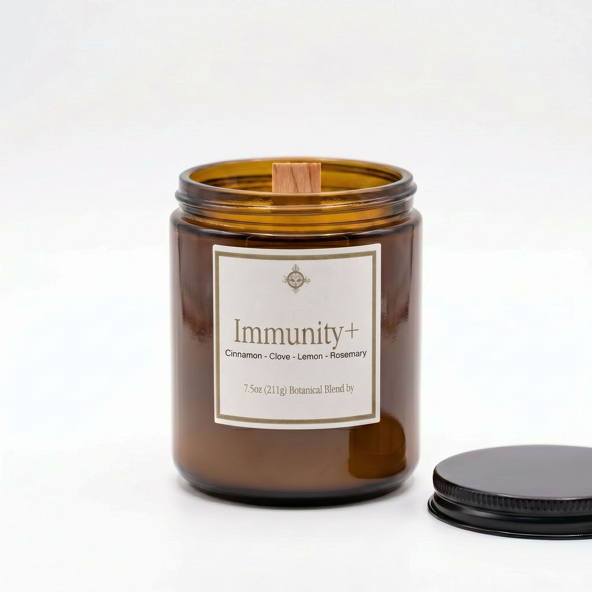 An amber glass jar candle with a white label reading 'Immunity+' and a wooden wick, shown on a white background with its black lid placed to the right.