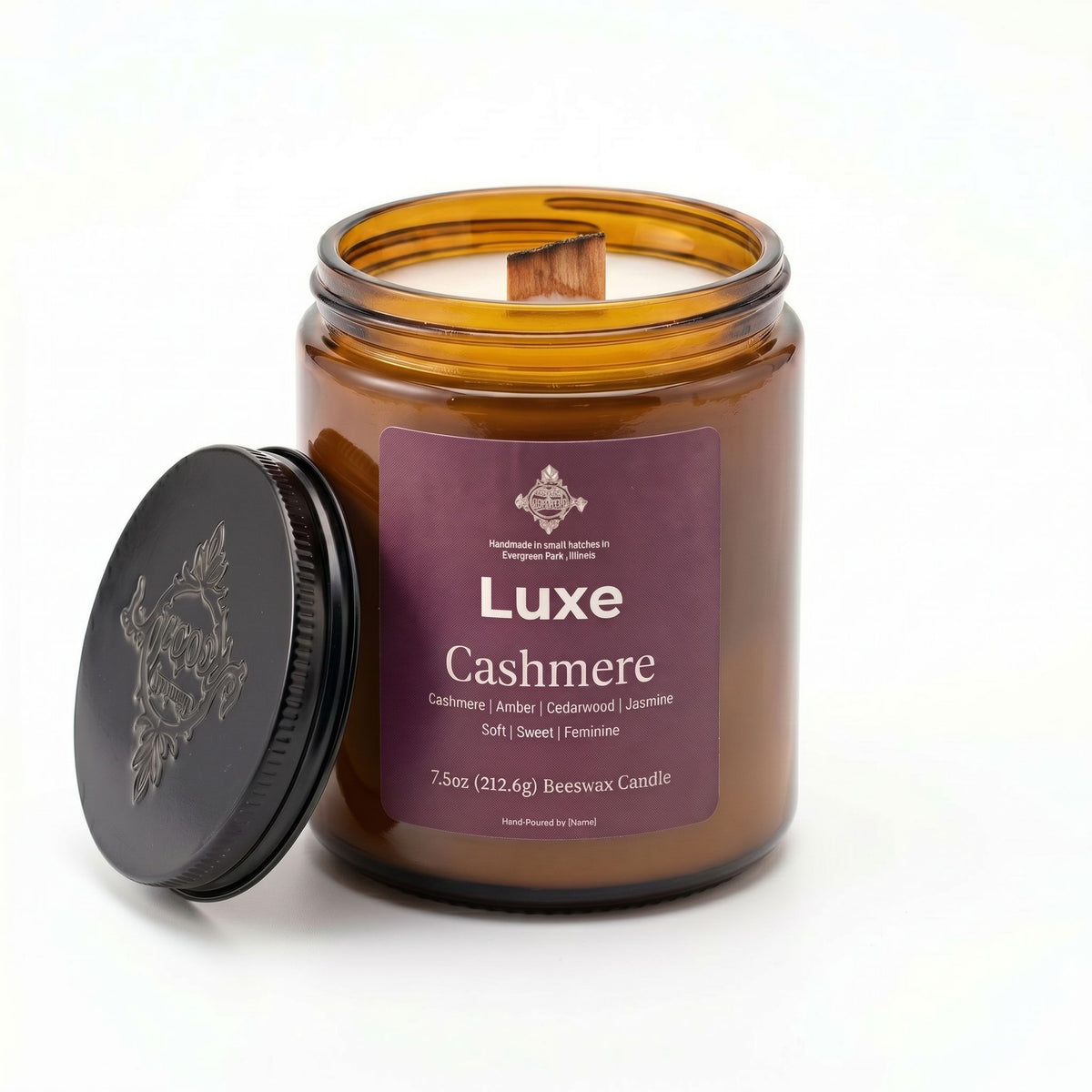 An amber glass jar candle with its black lid leaning against it on a white background. The front label reads 'Luxe Cashmere' and shows the brand 'Bergholt & Parker, Inc.