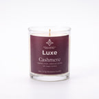 A 8oz Beeswax Candle in a clear glass jar with a deep plum-purple label reading 'Luxe Cashmere'.