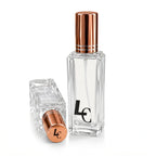 Blissfully Rooted Luxe Cashmere Eau de Parfum bottle with rose gold cap, one upright and one lying down showing the LC logo, on a white background