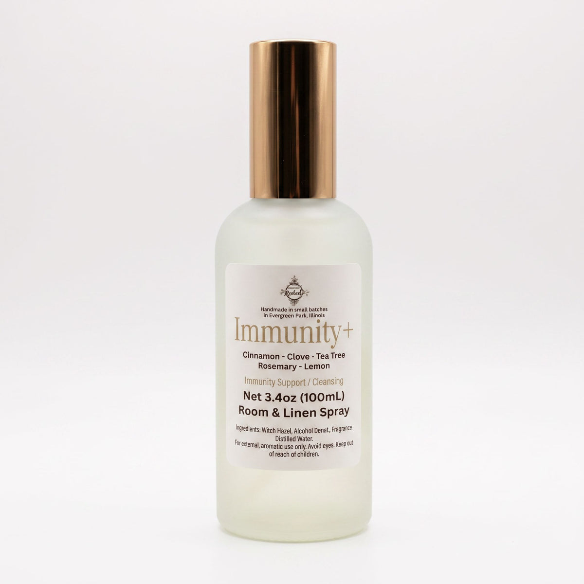 A frosted glass bottle of Immunity+ Room & Linen Spray with a metallic rose gold cap, shown on a clean white background.